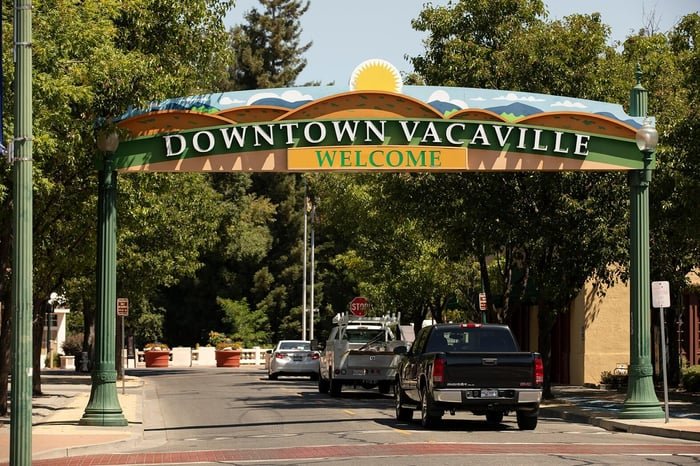 Downtown Vacaville welcome arch with cars driving through the city, highlighting reliable Vacaville Airport Shuttle service to SFO, OAK, SMF, and SJC airports.